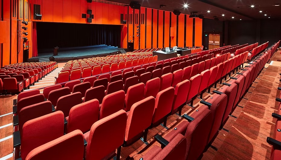 Rows of red seats facing the stage at Greenhalgh Theatre
